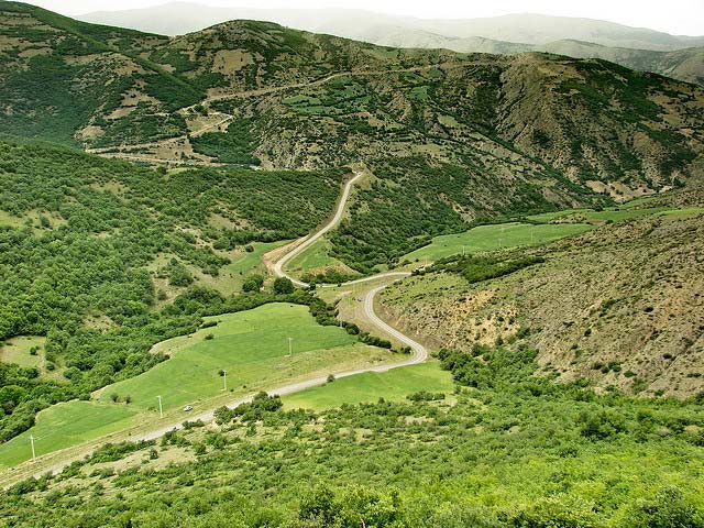 Arasbaran Protected Area Iran, Azarbaijan, Kaleibar جاده ای که در عکس ملاحظه می کنید مرکز شهرستان کلیبر را به روستای عاشقلو واقع در مرزجمهوری آذربایجان متصل می کند. این جاده تقریبا منطقه حفاظت شده ارسباران را به صورت قطری از جنوب شرقی به شمال غربی طی می کند. جاده کوهستانی و اکثرا پر پیچ و خم است. از بین جنگل ها و مراتع سرسبز عبور می کند و کلا مناظر شگفت انگیزی در آن وجود دارد. طول آن 70 تا 80 کیلومتر بوده و غیر از حدود 20 کیلومتر در اواسط آن بقیه آسفالت می باشد که احتمالا تا چند سال آینده کلا آسفالت شود. کل مسیر زیبا و دیدنی است فقط در مورد نقاط خاص توضیح می دهم. حدود 5 کیلومتر بعد از کلیبر به کمپ قلعه درسی می رسیم که نزدیکی قلعه بابک احداث شده است. با ادامه مسیر بعد از چند کیلومتر به هتل بابک می رسیم که ابتدای مسیر دوم صعود به قلعه بابک محسوب می شود. مسیر اول از کمپ قلعه درسی است. در ادامه مسیر بعد از هتل بابک و گذشتن از روستای آغویه به یک سه راهی در پایین دره مکیدی می رسیم که دومین کمپ در این دره احداث شده است. دره مکیدی یکی از زیباترین نقاط منطقه خفاظت شده می باشد. باز جاده اصلی را ادامه می دهیم و بعد از روستای اسکلو جاده خاکی می شود. پس از مدتی سربالایی شروع می شود و جاده تا بالای کوه می رود. در دو راهی به سمت راست می رویم. پس از مدتی سرازیری شروع شده و جاده آسفالت می شود. دره بسیار زیبای آینالی دیده می شود. کم کم حصارهای ایستگاه تحقیقاتی آینالی هم دیده می شوند. اگر خوش شانس باشید مرال ها را از پشت حصار می بینید. ولی پایین دره مرال ها به وفور موجودند. این ها را از استان گلستان آورده اند تا نسل آن را در این منطقه احیا کنند. جاده را همچنان رو به پایین ادامه می دهیم تا به دو راهی آینالی برسیم . از اینجا تا کمپ آینالی 5 کیلومتر راه خاکی است و مرال ها نیز آنجا دیده می شوند. اگر وارد آینالی نشویم و راه آسفالت را ادامه دهیم بعد از 14 کیلومتر به عاشقلو در مرز آذربایجان و کنار رود ارس می رسیم. در اینجا می توان یا از طریق خدا آفرین به کلیبر بازگشت و یا از طریق جاده مرزی به جلفا و تبریز رفت. 